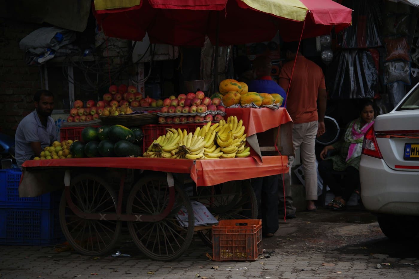 A fruit cart piled with bananas and melons